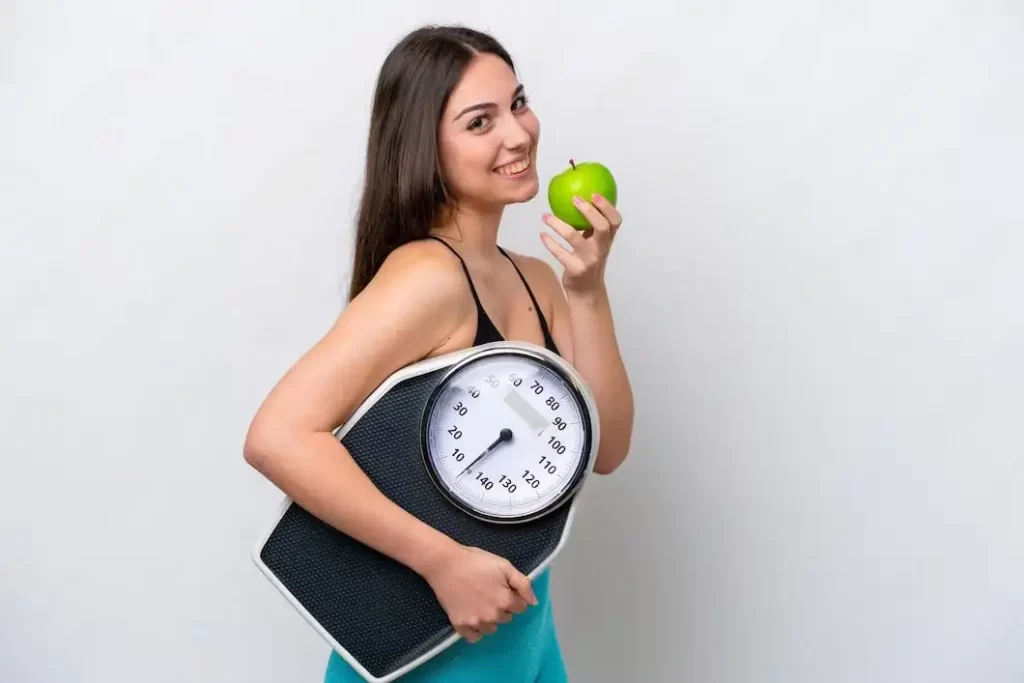 Mujer con pesa comiendo manzana verde